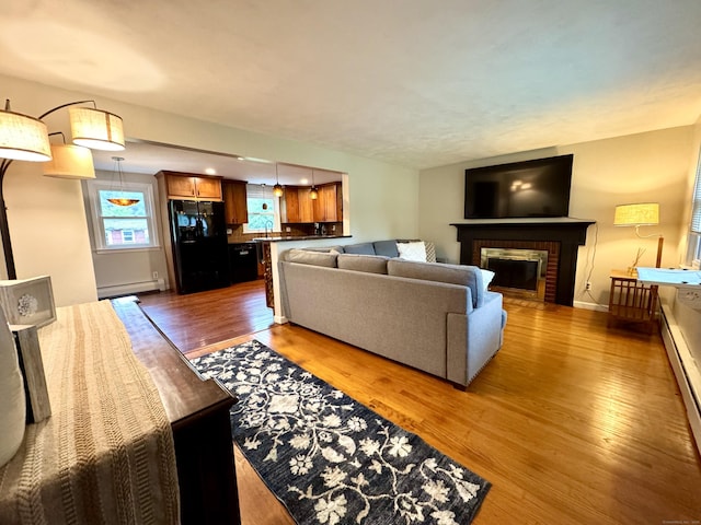 13 Lancer Dr, Enfield, CT 06082 - living room featuring a baseboard radiator, wood finished floors, a brick fireplace, and baseboards