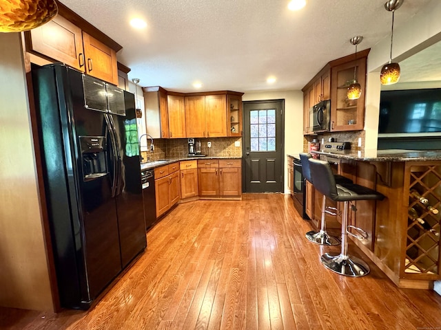 13 Lancer Dr, Enfield, CT 06082 - kitchen with black appliances, open shelves, light wood-type flooring, brown cabinets, and a peninsula
