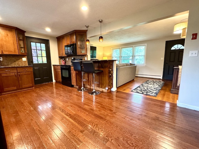 13 Lancer Dr, Enfield, CT 06082 - kitchen featuring black appliances, a baseboard heating unit, brown cabinets, hardwood / wood-style flooring, and recessed lighting