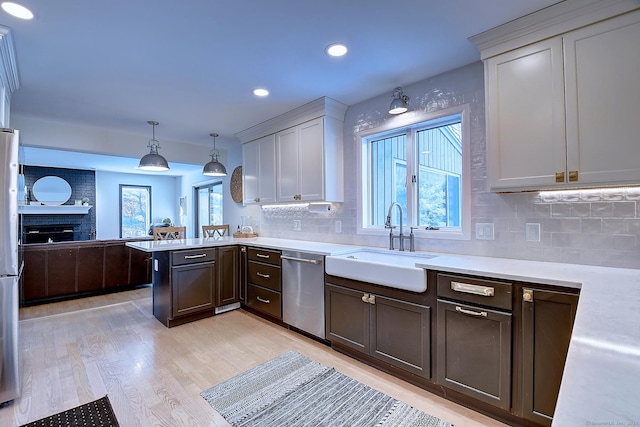 kitchen with stainless steel appliances, plenty of natural light, sink, and pendant lighting