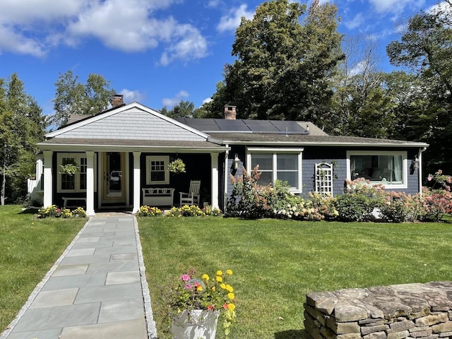 view of front of home featuring a front yard and solar panels