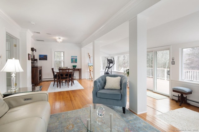 living room featuring baseboard heating, light hardwood / wood-style flooring, and ornamental molding