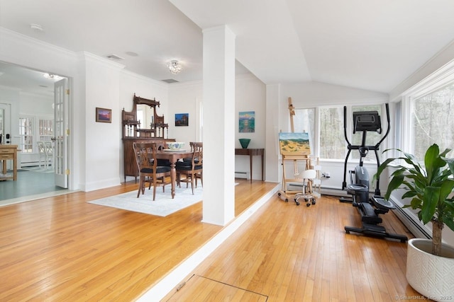 exercise room featuring hardwood / wood-style flooring, crown molding, a baseboard heating unit, and lofted ceiling