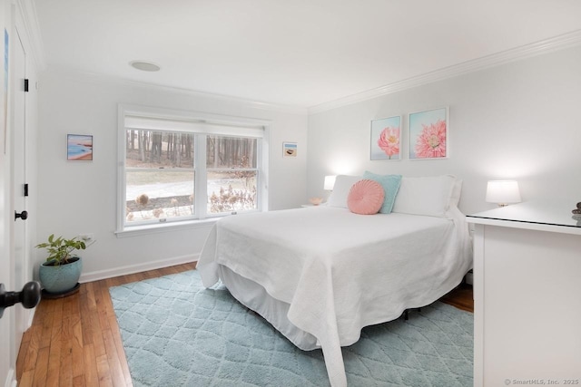 bedroom with ornamental molding and hardwood / wood-style flooring