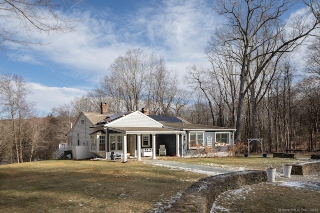 view of front of home with a front yard and solar panels