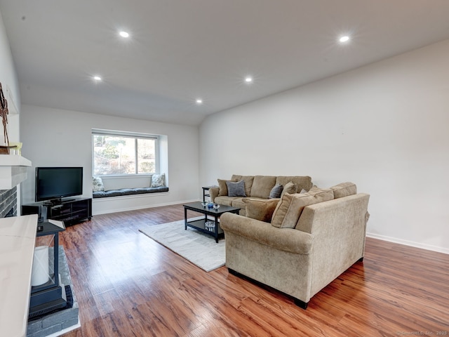 living room with recessed lighting, baseboards, light wood-style flooring, and a tile fireplace