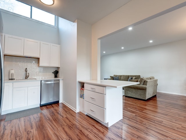 kitchen with stainless steel dishwasher, wood finished floors, and light countertops