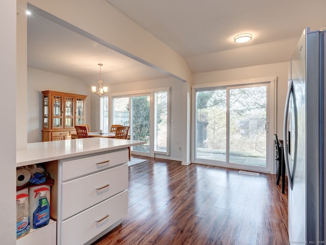 kitchen featuring light countertops, freestanding refrigerator, wood finished floors, a notable chandelier, and white cabinetry