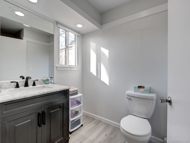 bathroom with vanity, baseboards, wood tiled floor, recessed lighting, and toilet