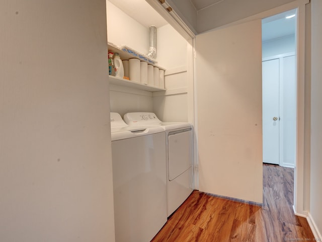 laundry room with washing machine and clothes dryer, laundry area, and light wood-style floors