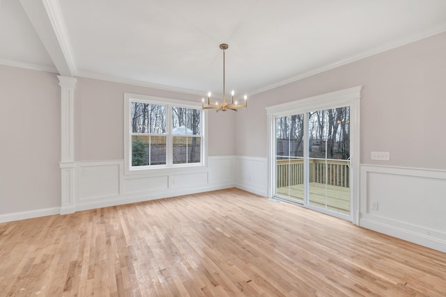 unfurnished dining area with crown molding, plenty of natural light, light hardwood / wood-style floors, and an inviting chandelier