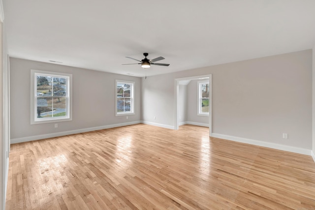 unfurnished room with plenty of natural light, light wood-type flooring, and ceiling fan