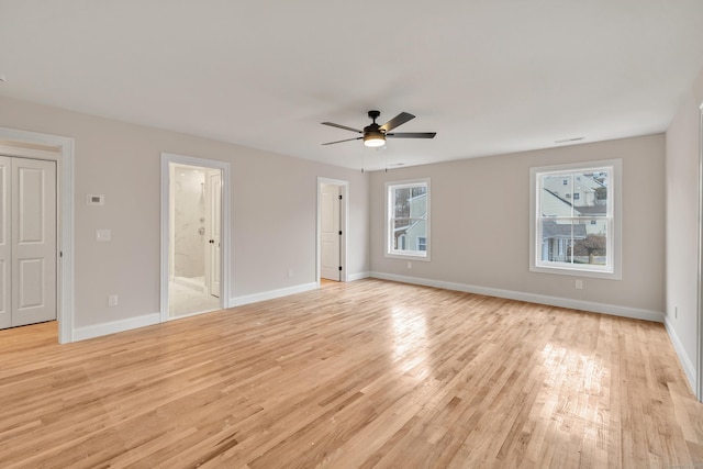 spare room featuring light wood-type flooring, ceiling fan, and a wealth of natural light