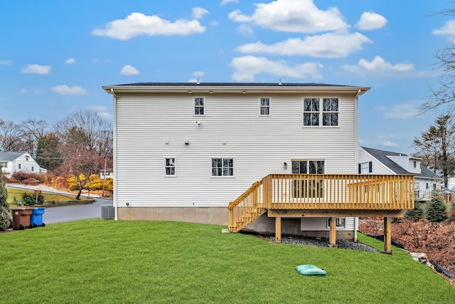 back of house featuring a deck, central AC unit, and a lawn