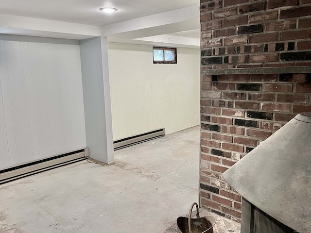 basement with a baseboard heating unit and wood walls