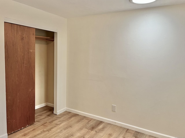 unfurnished bedroom with a closet and light hardwood / wood-style flooring