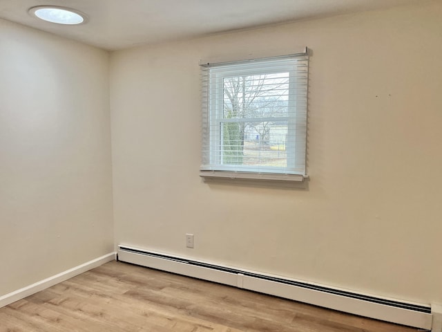 empty room featuring light wood-type flooring and a baseboard radiator