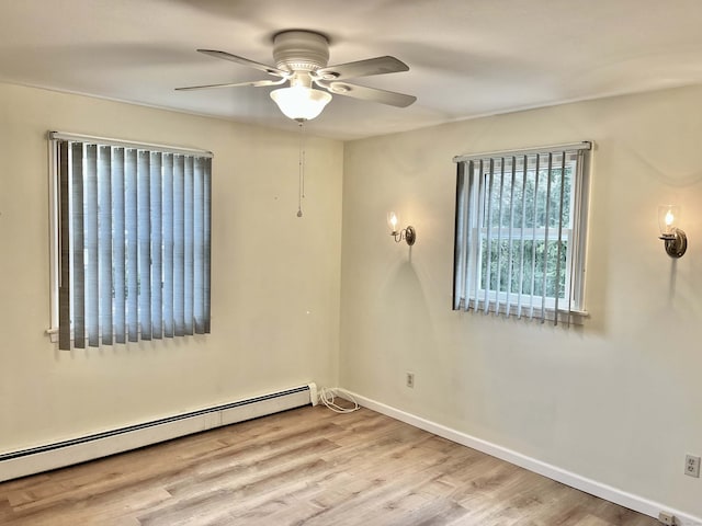 empty room with a baseboard heating unit, ceiling fan, and light wood-type flooring