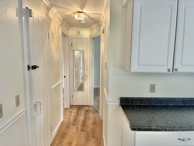 hall with ornamental molding and light hardwood / wood-style flooring