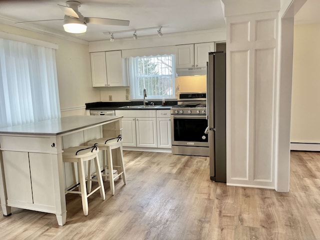 kitchen featuring a kitchen island, sink, crown molding, stainless steel appliances, and white cabinets