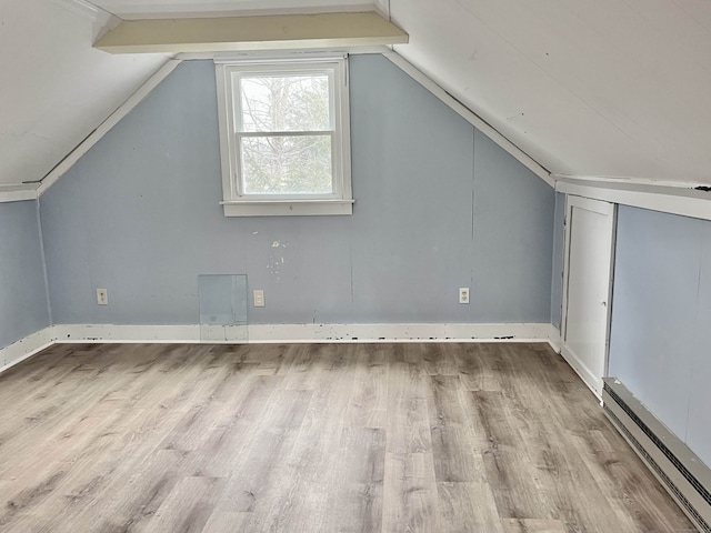 bonus room with baseboard heating, lofted ceiling, and light hardwood / wood-style flooring