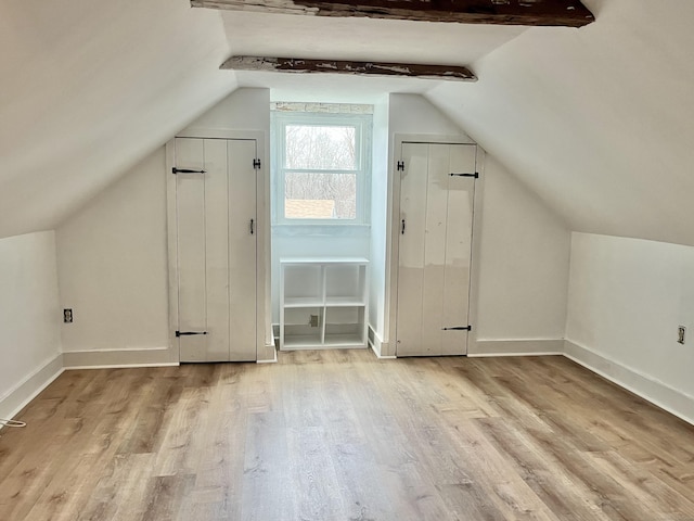 additional living space with vaulted ceiling and light hardwood / wood-style floors