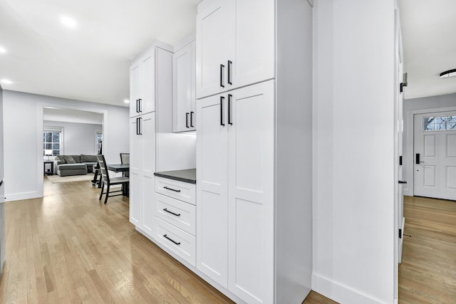 kitchen featuring a healthy amount of sunlight, white cabinets, and light wood-type flooring