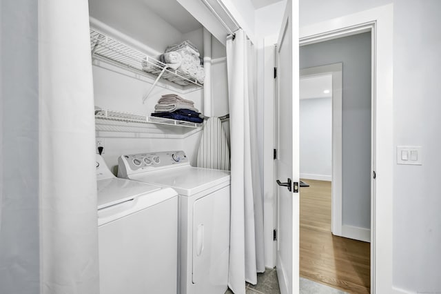 laundry room featuring wood-type flooring and washer and dryer