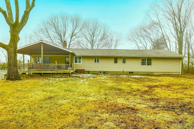 rear view of property featuring a yard and covered porch