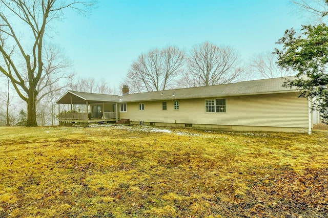 back of property featuring a lawn and a sunroom