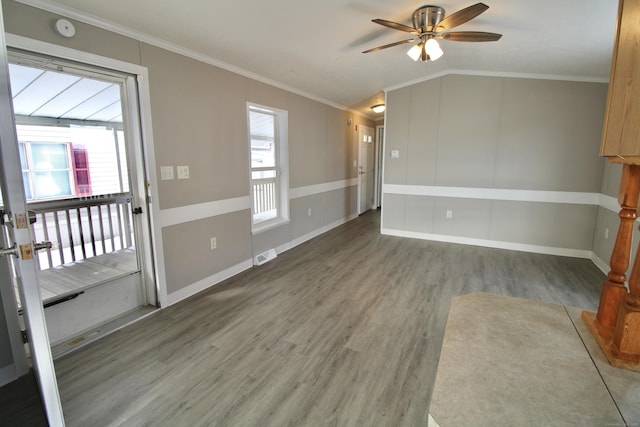 spare room with lofted ceiling, dark wood-type flooring, crown molding, and ceiling fan