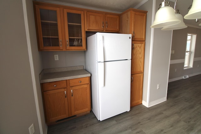 kitchen featuring dark hardwood / wood-style floors, white refrigerator, and ornamental molding