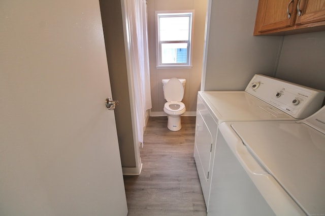 washroom with light hardwood / wood-style flooring and washing machine and dryer