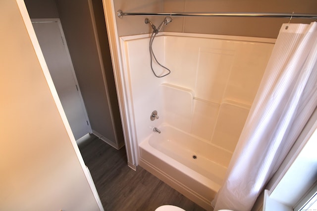 bathroom with toilet, hardwood / wood-style flooring, and shower / bathtub combination with curtain