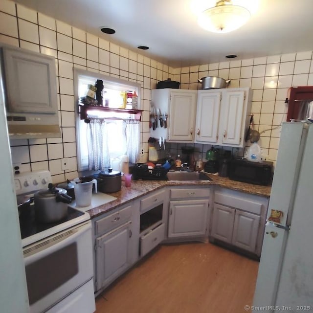 kitchen featuring sink, backsplash, gray cabinets, white appliances, and light hardwood / wood-style floors