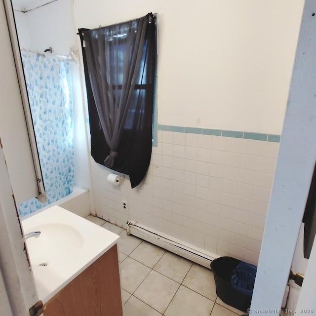 bathroom with tile patterned flooring, vanity, a baseboard heating unit, and tile walls