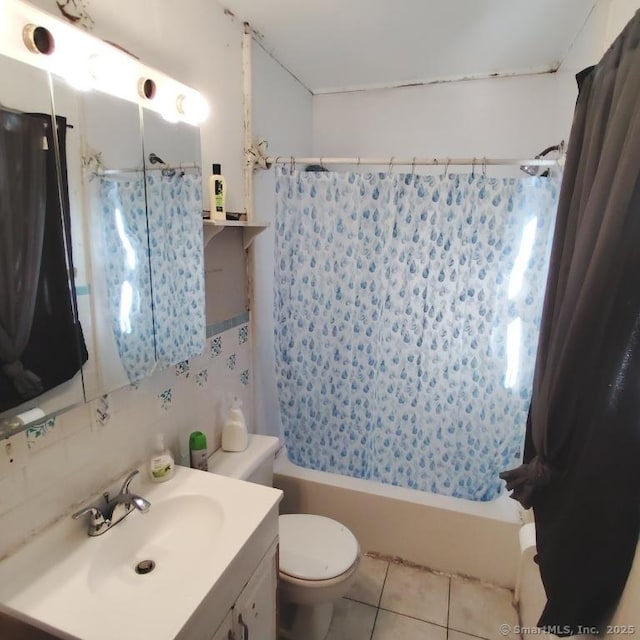 full bathroom with tile patterned flooring, backsplash, toilet, vanity, and shower / bath combo with shower curtain