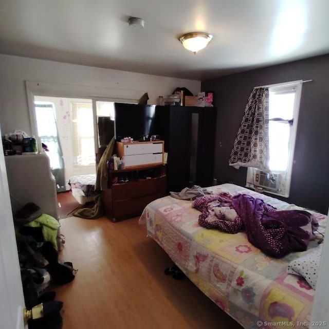 bedroom with hardwood / wood-style flooring and cooling unit