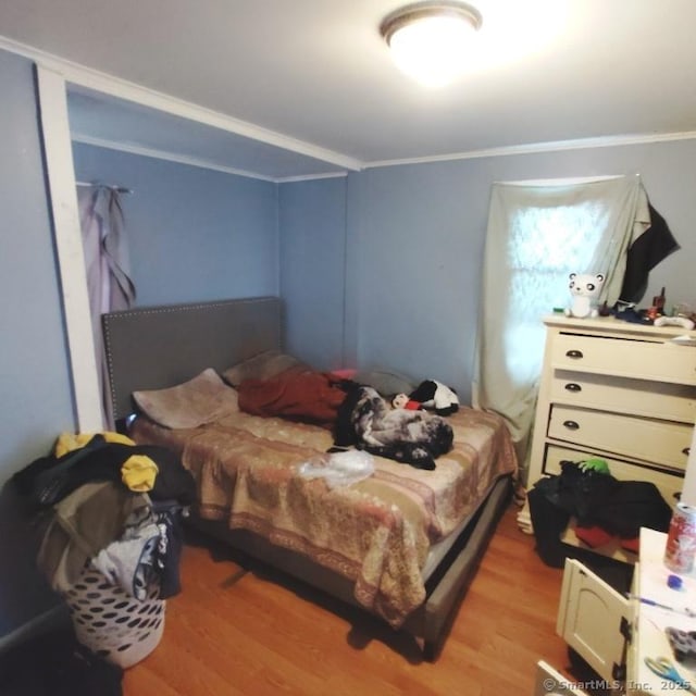 bedroom featuring light wood-type flooring and ornamental molding