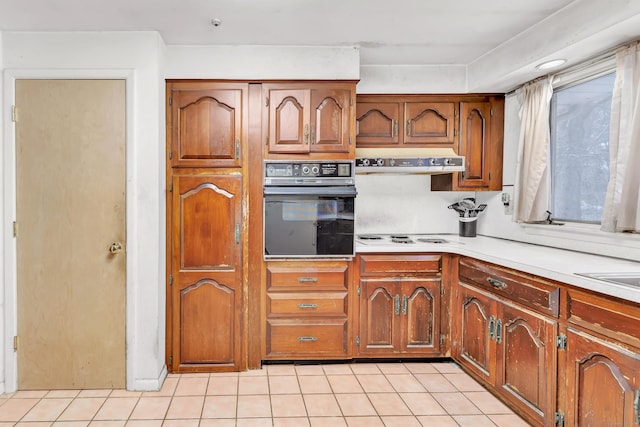 kitchen featuring light tile patterned floors, white cooktop, and black oven