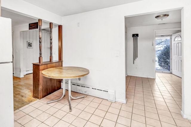 tiled dining space featuring a baseboard radiator