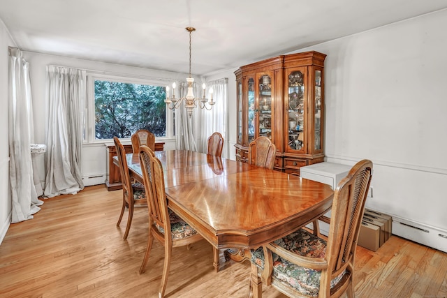 dining room with a baseboard heating unit, a chandelier, and light hardwood / wood-style floors