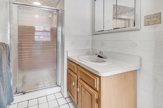 bathroom with tile patterned floors, vanity, and walk in shower