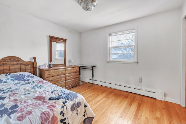 bedroom featuring baseboard heating and light hardwood / wood-style flooring