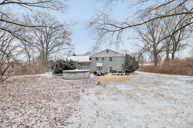 snow covered house with a covered pool