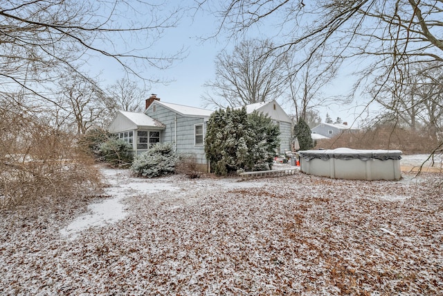 view of snowy exterior featuring a covered pool