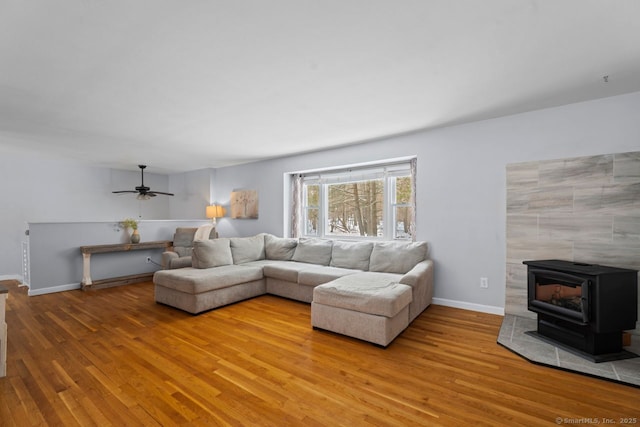 living room with light hardwood / wood-style flooring and a wood stove