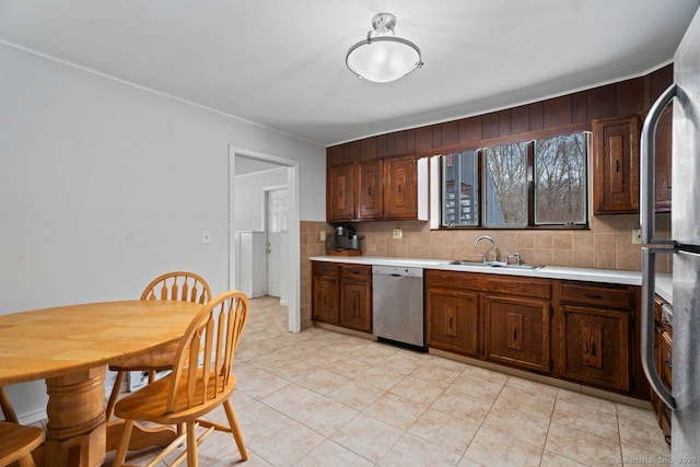 kitchen with tasteful backsplash, dark brown cabinetry, dishwasher, and sink