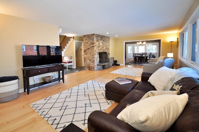 living room with hardwood / wood-style flooring, a fireplace, and an inviting chandelier