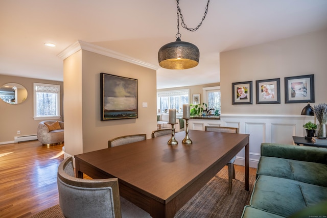 dining space with light hardwood / wood-style flooring, a baseboard radiator, and crown molding